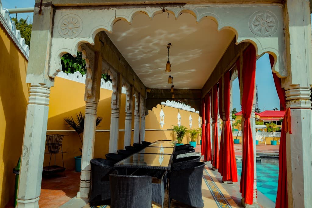 Carved marble colonnade and outdoor dining by the pool