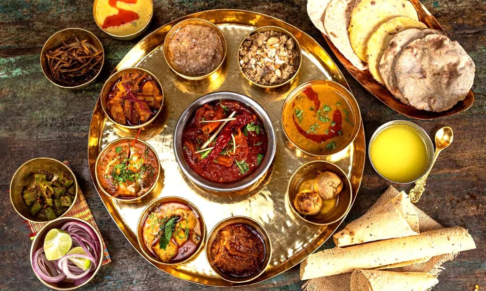 Royal Rajasthani brass thali feast with authentic regional curries and breads