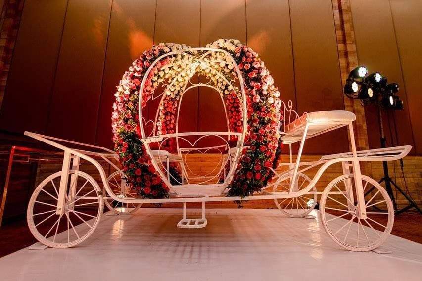 Ornate white royal carriage decorated with red roses for milestone party celebrations