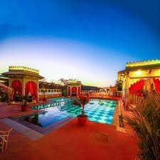 Vibrant twilight poolside courtyard lit for gala evening parties and celebrations at Castle Narela