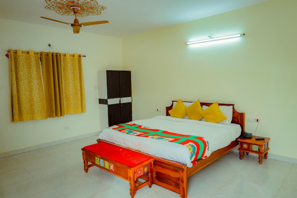 Garden Room bedroom interior with red bench and yellow curtains