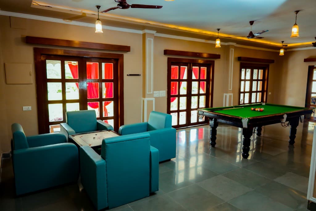 Royal indoor game lounge with billiards snooker table and carrom seating lounge at Castle Narela