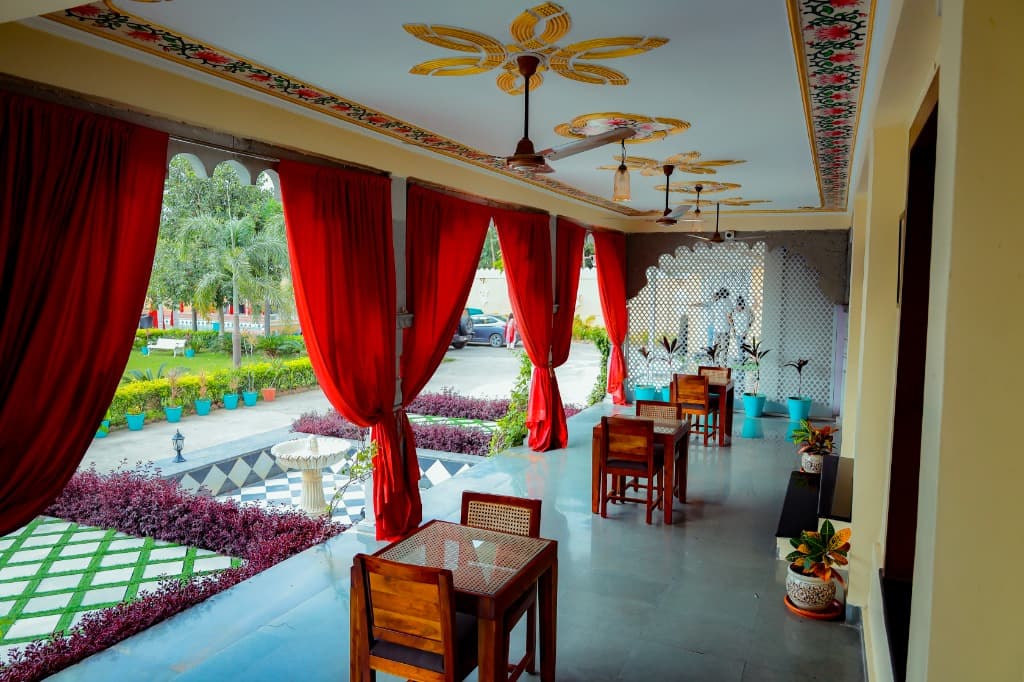 Painted veranda dining corridor overlooking lush garden lawns and central fountain